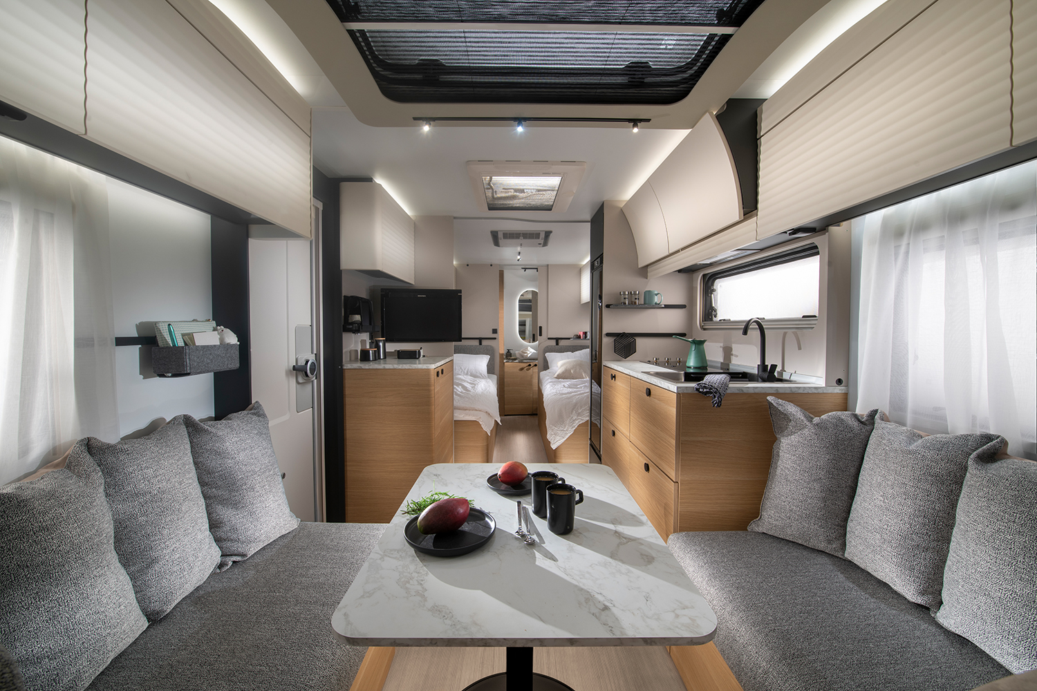 Der ADRIA ADORA 572 UT mit Sitzgruppe vorne, Einzel-Längsbetten mittig und Bad im Heck. 